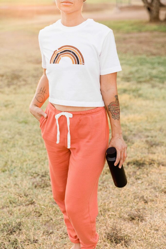 Young woman in a sporty outfit carrying a reusable water bottle in an park so that she can hydrate properly throughout her day