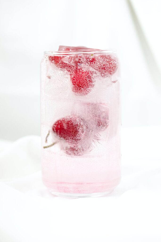 Chilled berry, cherries in this case, infused water in a see-through glass