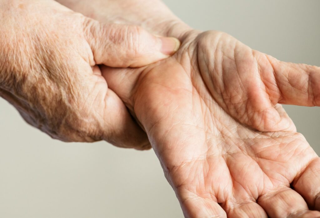 wrist pain in yoga, mature white person's hands close up